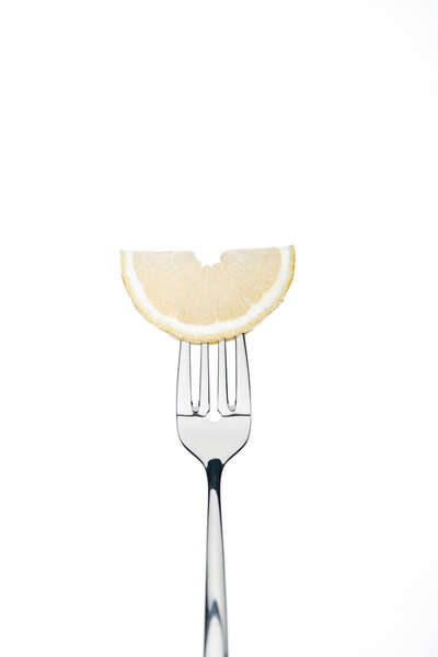 half slice of fresh ripe juicy lemon on fork isolated on white