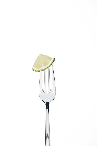 quarter slice of fresh juicy lime on fork isolated on white isolated on white