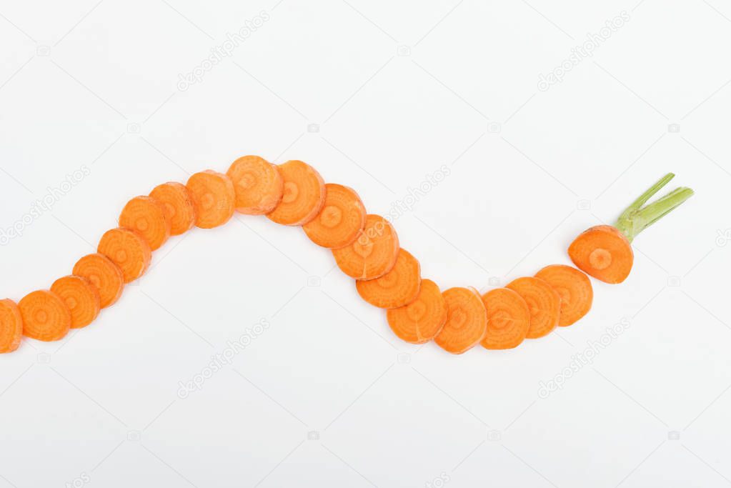 top view of ripe raw carrot slices arranged in horizontal curved line isolated on white