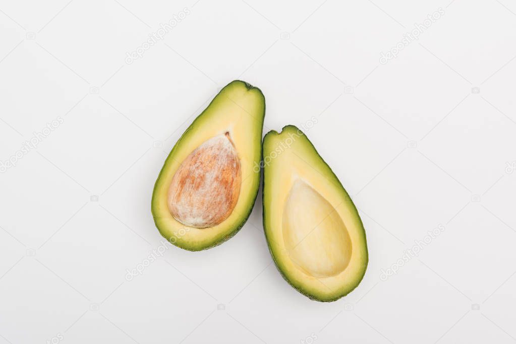 top view of ripe avocado fruit halves on grey background