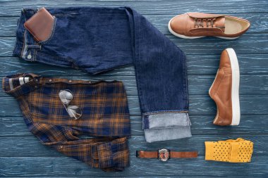 Top view of trendy male clothes, shoes and accessories on wooden background clipart