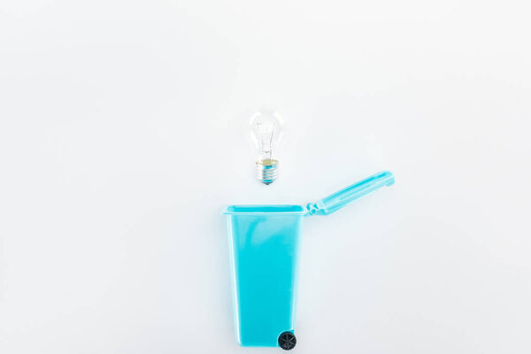Top view of blue toy trashcan and bulb on grey background