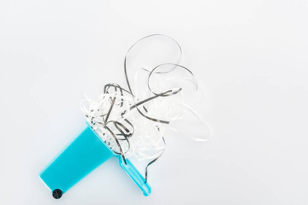 Вид сверху на бумажные полоски и синий игрушечный трашкан
 