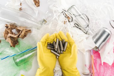 Piller can arasında tutan adam görünümünü kırpılmış, cam şişe, plastik torbalar, kağıt şeritler, kağıt ve Plastik tüpler