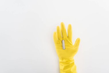 Cropped view of man in yellow rubber gloves holding battery on grey background  clipart