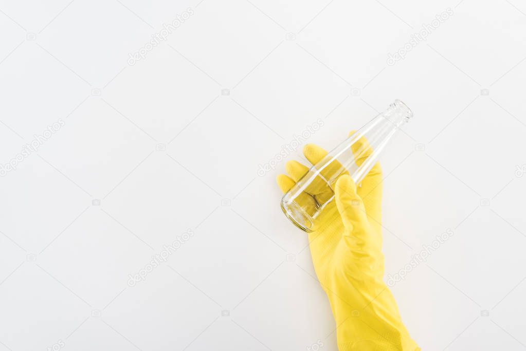 Partial view of man in yellow rubber gloves holding empty glass bottle