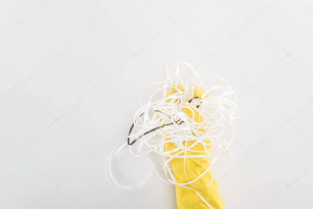 Cropped view of man in yellow rubber gloves holding paper strips on grey background 