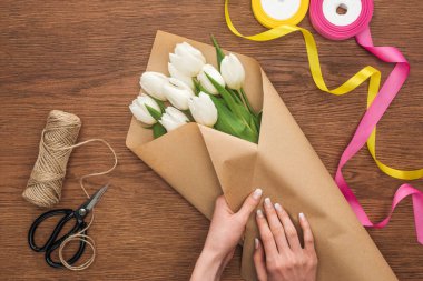 Kırpılan görünümünü üzerinde kesme zanaat tulip buket üzerinde ahşap arka plan yapma çiçekçi