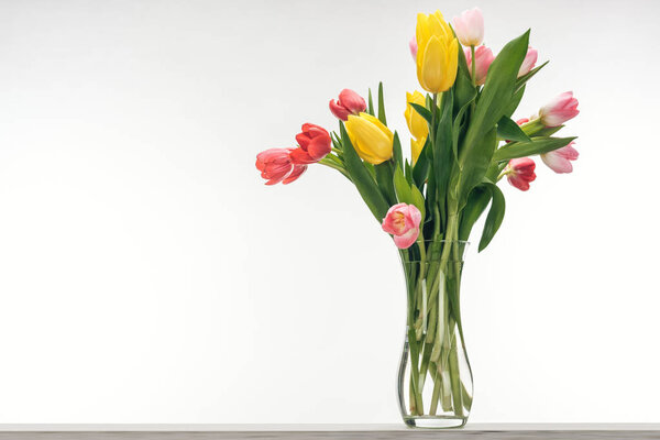 bouquet of colorful tulips in vase for international womens day, on white