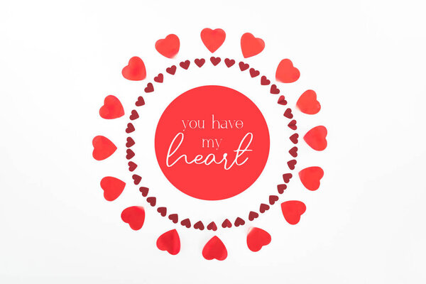 view from above of circles made of red heart symbols isolated on white with "you have my heart" lettering