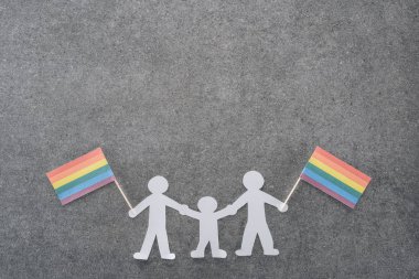 beyaz kağıt aynı seks aile gökkuşağı bayrakları ile gri arka plan üzerinde lgbt kavramı kesmek.