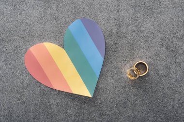 Gökkuşağı renkli kağıt kalp ve alyans gri arka plan, lgbt kavramı üzerinde