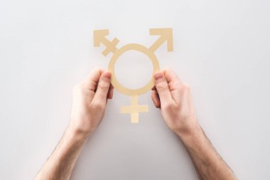partial view of man holding white paper gender sign on grey background, lgbt concept clipart