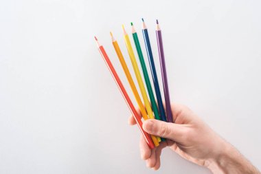 Gökkuşağı renkli kalemler üzerinde gri arka plan, lgbt kavramı ile görünümünü erkek eli kırpılmış