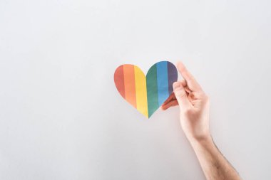 Kağıt kalp gri arka plan, lgbt kavramı üzerinde renkli gökkuşağı ile görünümünü erkek eli kırpılmış