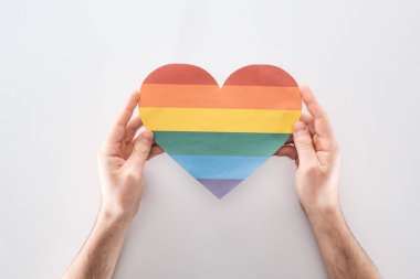 Kağıt kalp gri arka plan, lgbt kavramı üzerinde kısmi kağıt gökkuşağı tutan adam görünümünü renkli