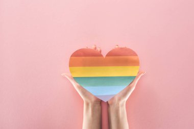gökkuşağı tutan kadın kısmi görünümünü kağıt kalp pembe arka plan, lgbt kavramı üzerinde renkli