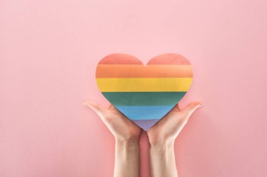Kağıt kalp pembe arka plan, lgbt kavramı üzerinde kısmi eller gökkuşağı ile görünümünü renkli