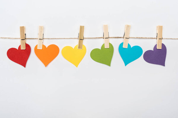 rainbow multicolored paper hearts on rope isolated on white, lgbt concept