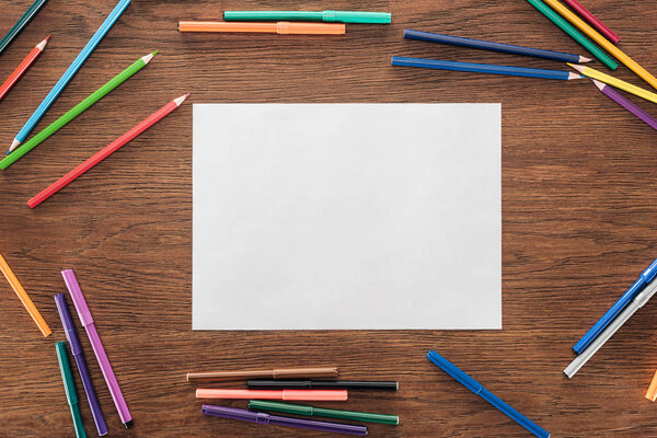 пустая бумага с цветными карандашами и войлочными ручками на деревянной коричневой поверхности, концепция lgbt
