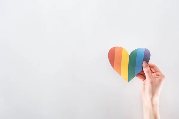 裁剪的观点的女性手与彩虹色的纸心脏在灰色的背景 Lgbt — 图库照片