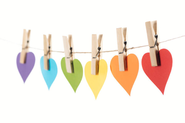 selective focus of rainbow multicolored paper hearts on rope isolated on white, lgbt concept