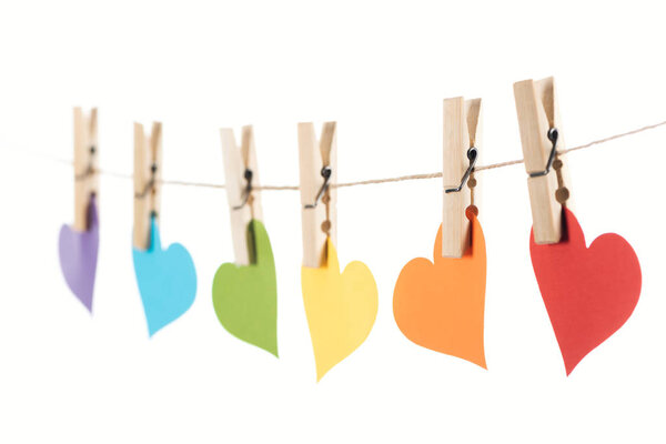selective focus of rainbow multicolored paper hearts on rope isolated on white, lgbt concept