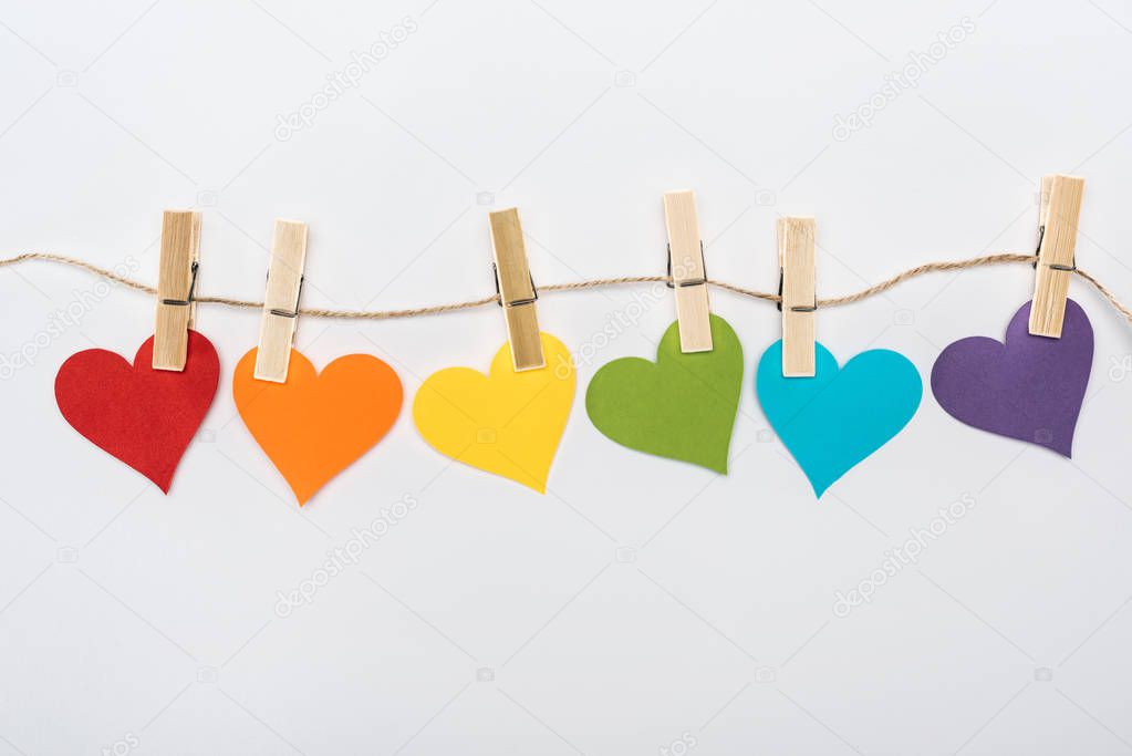 rainbow multicolored paper hearts on rope isolated on white, lgbt concept