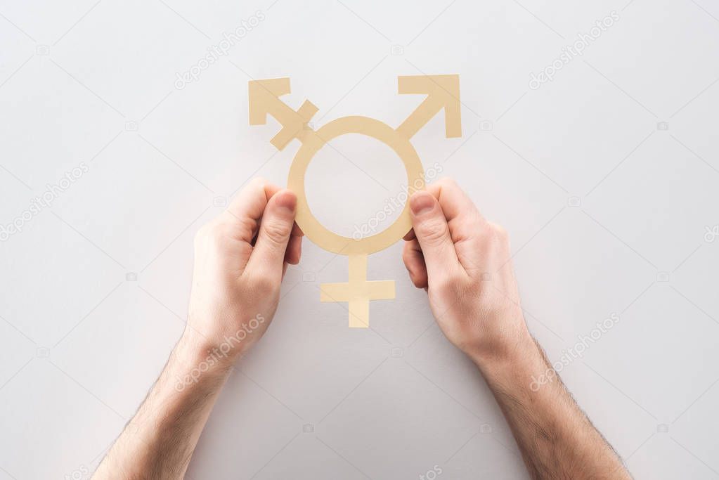 partial view of man holding white paper gender sign on grey background, lgbt concept