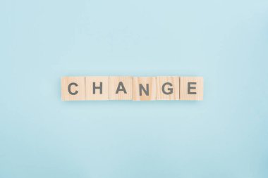 top view of change lettering made of wooden blocks on blue background clipart
