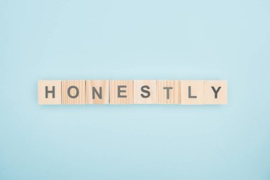 top view of honestly lettering made of wooden cubes on blue background  clipart
