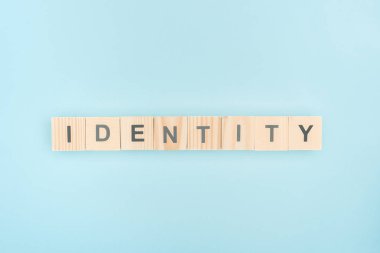 top view of identity lettering made of wooden cubes on blue background
