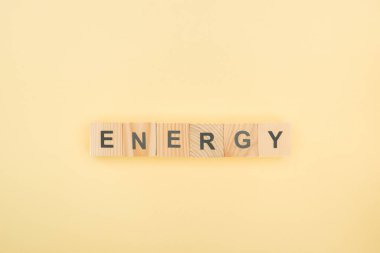 ahşap küpler sarı zemin üzerine yapılan enerji yazı üstten görünüm