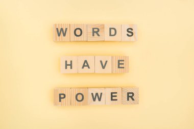 top view of phrase words have power lettering with wooden cubes on yellow background clipart