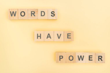 top view of phrase words have power lettering with wooden cubes on yellow background clipart