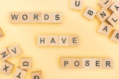 top view of words have poser lettering with wooden cubes on yellow background clipart