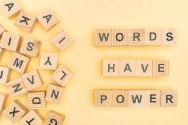 top view of phrase words have power lettering with wooden cubes on yellow background clipart