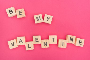 top view of be my valentine lettering made of wooden blocks on pink background clipart