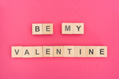 top view of be my valentine lettering made of wooden cubes on pink background clipart