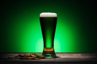 bardak yeşil bira yakınındaki altın sikke st patricks günü yeşil zemin üzerine
