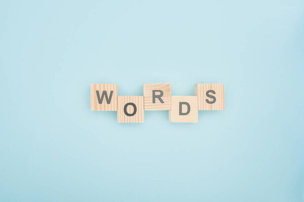 top view of words lettering made of wooden blocks on blue background