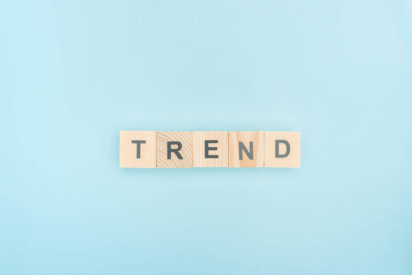 top view of trend lettering made of wooden cubes on blue background