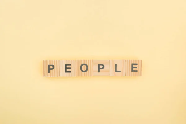 Top View People Lettering Made Wooden Cubes Yellow Background — Stock Photo, Image
