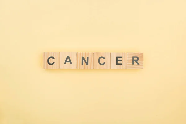 Top View Καρκίνου Γραμμάτων Των Ξύλινων Κύβων Κίτρινο Φόντο — Φωτογραφία Αρχείου