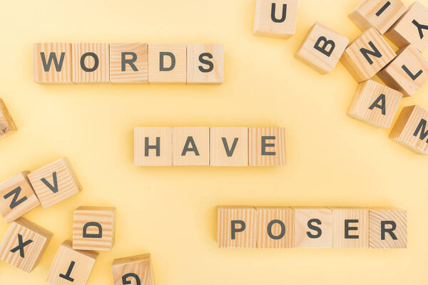 top view of words have poser lettering with wooden cubes on yellow background