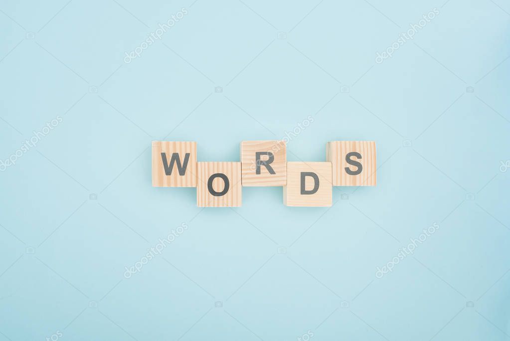 Top view of words lettering made of wooden blocks on blue background
