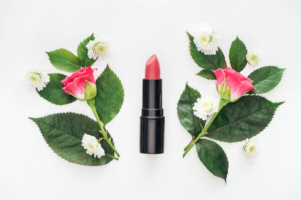 top view of lipstick between boutonnieres isolated on white