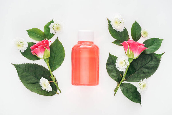 top view of bottle with orange lotion between boutonnieres isolated on white