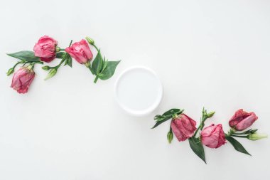 top view of compositions with pink eustoma and beauty cream in bottle on white background clipart
