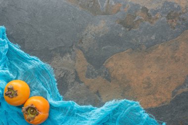 turuncu persimmons üstten görünüm kopya alanı ile mavi kumaş üzerine